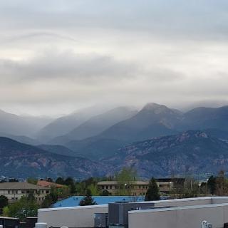 A serene view of mist-covered mountains under a cloudy sky.