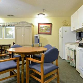 A cozy kitchen and dining area with a round table and chairs.