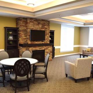 A cozy living room with a stone fireplace and comfortable seating arrangements.