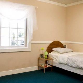 A simple and clean bedroom with a single bed near the window.