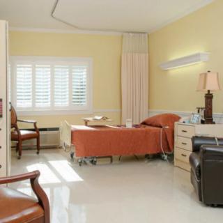 A clean and well-lit hospital room with a bed and medical equipment.
