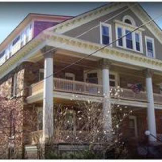 A traditional two-story house with prominent columns and a spacious porch.