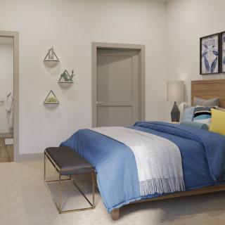 A modern bedroom with a neatly made bed, stylish decor, and warm lighting.