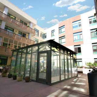 A modern courtyard with a glass structure surrounded by multi-story buildings.