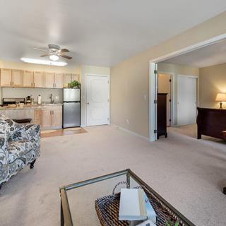 A modern, open-plan living area with a kitchen and adjoining room.
