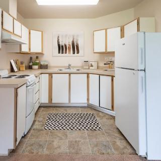 A clean and organized kitchen with white cabinets and appliances.