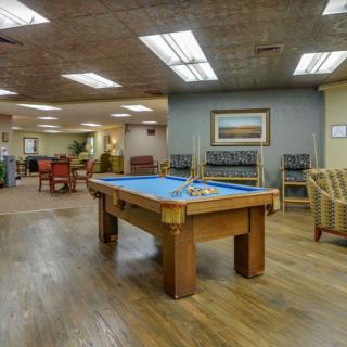 A spacious recreation room featuring a pool table and comfortable seating.