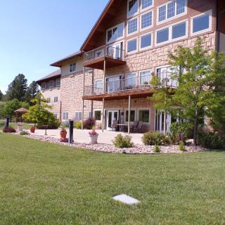 A spacious house with large windows and balconies overlooking a well-maintained lawn.