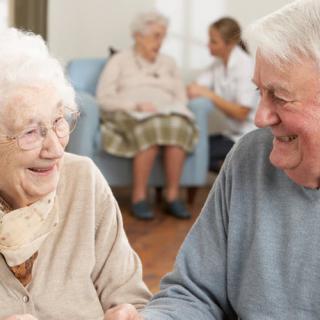 Elderly individuals sharing a joyful moment in a nursing home setting.