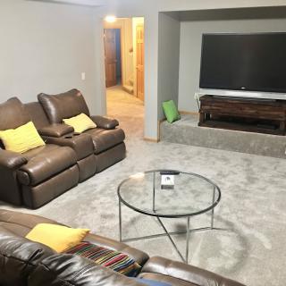 A cozy living room featuring a comfortable sofa, a large television, and a modern glass coffee table.