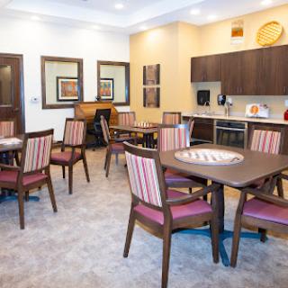 A modern dining area featuring stylish furniture and a well-equipped kitchen.