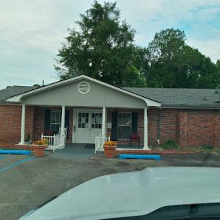 A view of a brick building with a welcoming front entrance and landscaped planters.