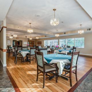 Spacious dining room with elegant chandeliers and neatly arranged tables.