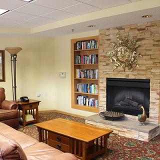A cozy living room with a fireplace, bookshelf, and comfortable seating.
