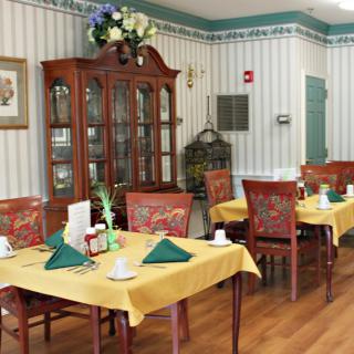 A quaint dining room with elegantly set tables and classic wooden furniture.