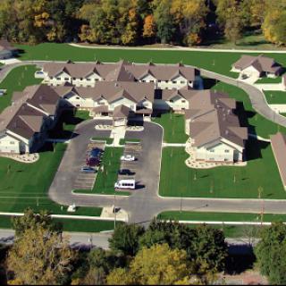 Aerial view of a well-maintained residential housing complex surrounded by lush greenery.