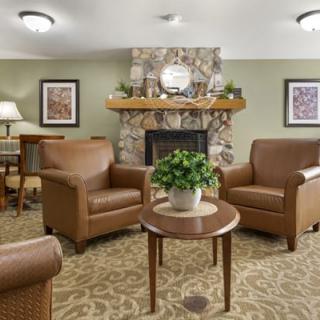 A cozy living room with leather armchairs and a fireplace.