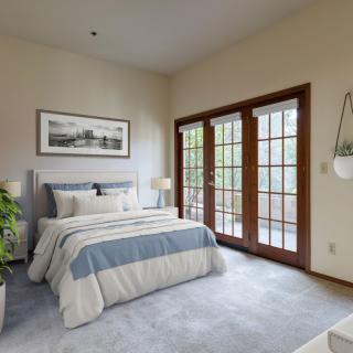 A cozy bedroom with a neatly made bed, featuring French doors and abundant natural light.