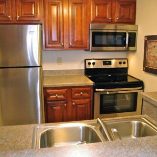 A modern kitchen featuring stainless steel appliances and wooden cabinets.