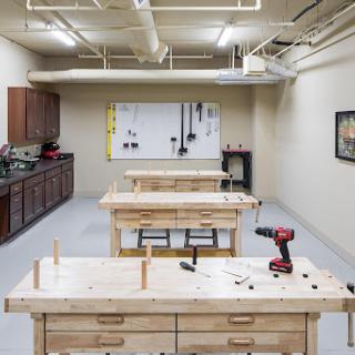 A well-equipped woodworking workshop featuring multiple work tables and tool storage.