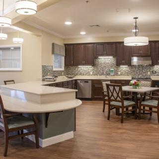 A modern kitchen and dining area with an open layout and wooden flooring.