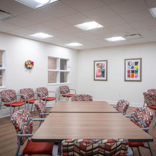 A well-lit meeting room with modern chairs and decorative artwork on the walls.
