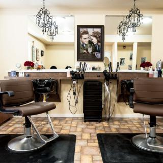 A well-organized hair salon interior with chairs, mirrors, and styling tools.