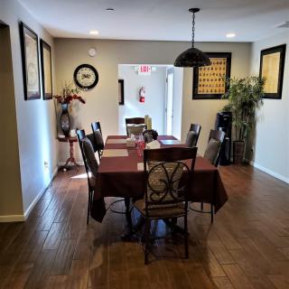 A well-decorated dining room with a large table, chairs, and wall artwork.