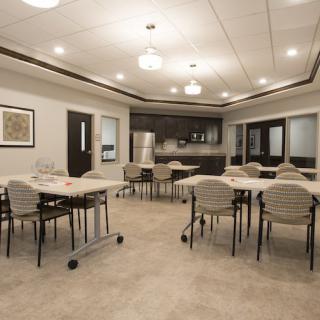 A modern conference room with multiple tables and chairs, well-lit and designed for meetings.