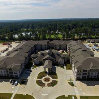 Aerial view of a large residential building surrounded by greenery.
