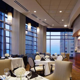 An elegant restaurant dining area with large windows offering a city view.