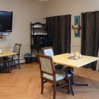 A cozy dining area with tables, chairs, a television, and decorative elements.