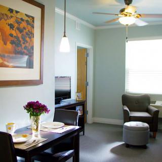 A cozy living room with a dining area, featuring stylish furniture and natural lighting.