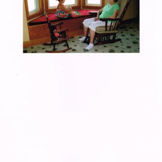 Two people sitting near a table by the window.