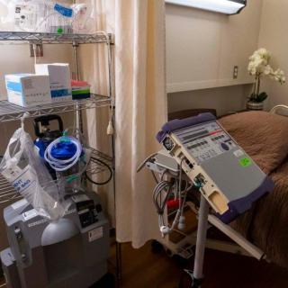 A hospital room equipped with medical devices, including a ventilator and hospital bed.