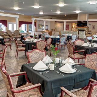 An elegantly set dining area with multiple tables and chairs, ready for guests.