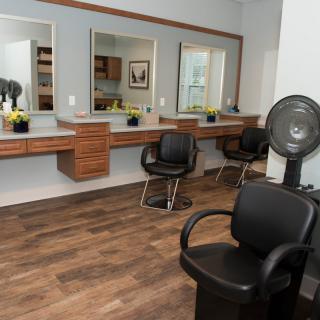 A modern hair salon with styling stations and comfortable chairs.