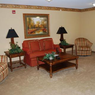 A cozy living room with a sofa, armchairs, and decorative elements.