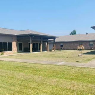 A tranquil view of a modern residential complex with well-maintained lawns and clear blue skies.
