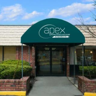 Entrance of a business with an awning and logo above the door.