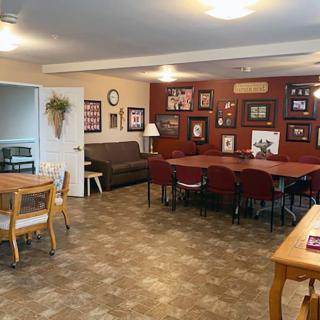 A cozy meeting room with a large conference table, surrounded by chairs and adorned with wall decorations.