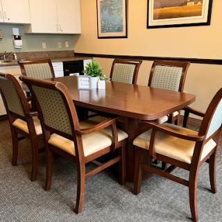 A cozy dining area featuring a wooden table surrounded by comfortable chairs, ideal for meetings or gatherings.