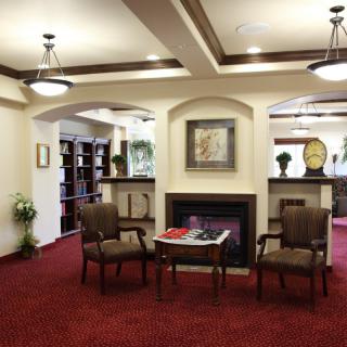A welcoming lobby area featuring comfortable seating, a fireplace, and bookshelves.