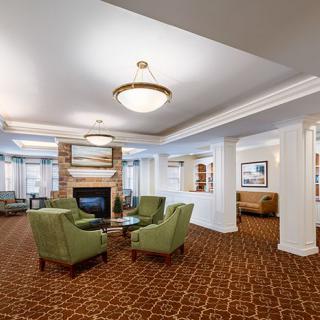 A spacious and elegant lobby with comfortable seating arranged around a fireplace.