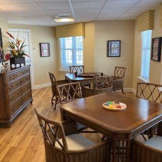 A cozy dining room with wooden tables and chairs, surrounded by warm decor and natural light.