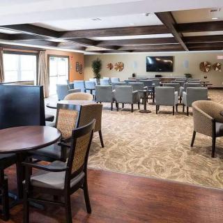 A modern conference room with arranged seating, tables, and a large television.
