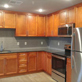 A modern kitchen with wooden cabinets and stainless steel appliances.