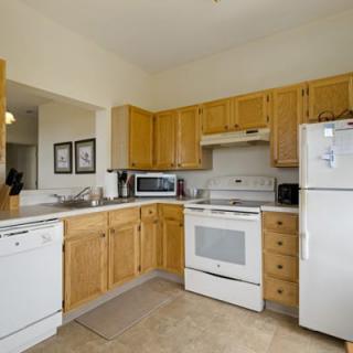 A cozy kitchen featuring wooden cabinets and standard appliances.