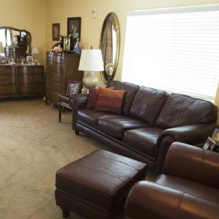 A cozy living room with leather furniture and a large window.