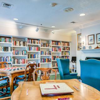 A cozy library reading room with shelves full of books and comfortable seating.